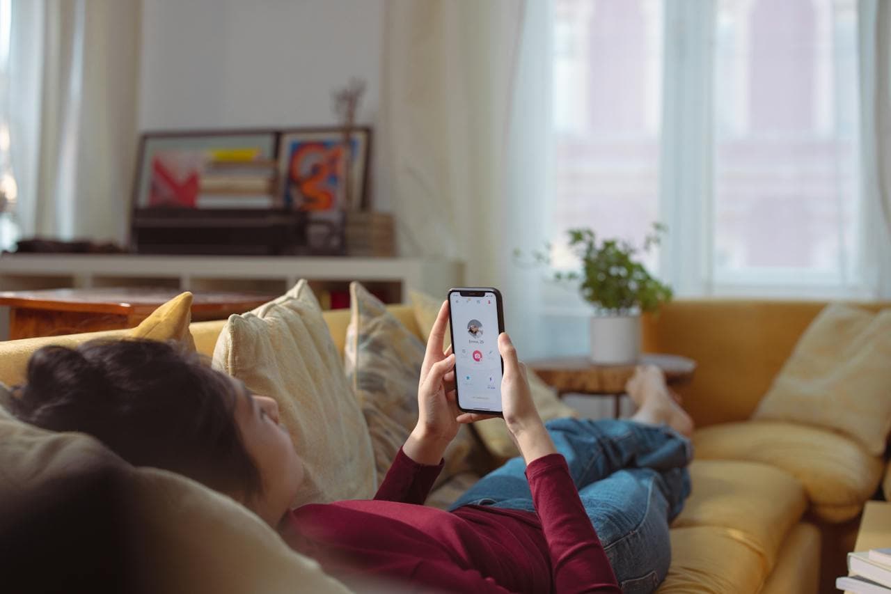 Person dating on an app laying on the couch