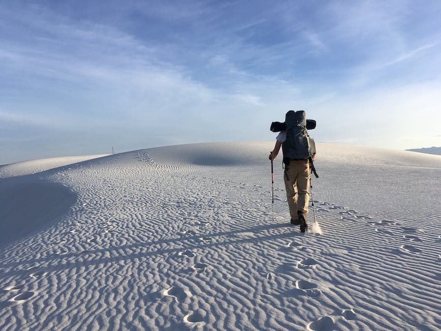 Photo of Man Holding Hiking Poles on Snow Field