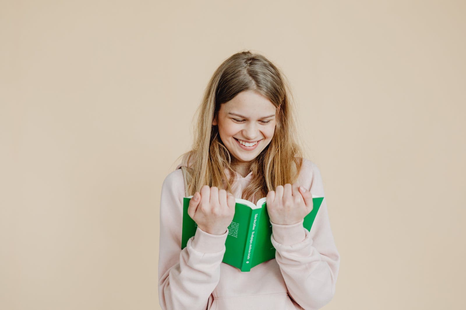 A Happy Woman in Beige Long Sleeves Reading a Book