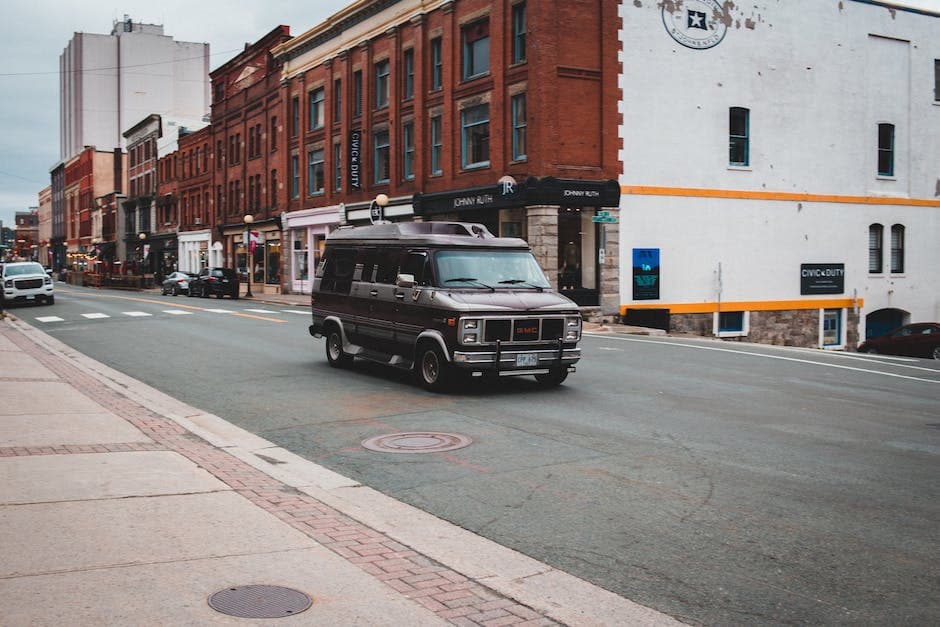 Black minivan driving on asphalt road