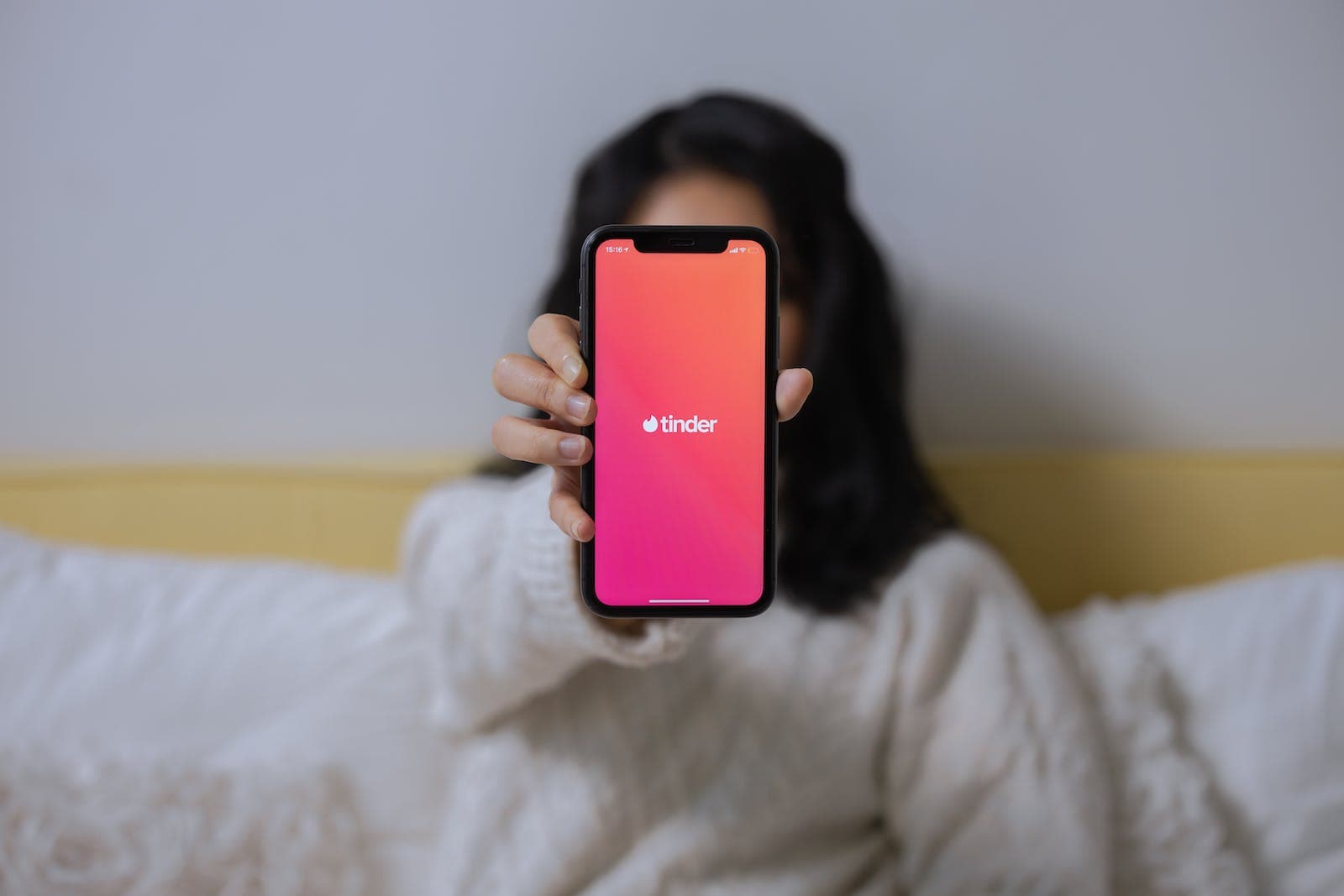 A Woman Showing Her Smartphone Showing the App Tinder